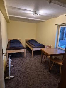 ein Zimmer mit zwei Betten und einem Tisch in der Unterkunft Montage Wohnung zum Walnussbaum Deutschhof in Deutschhof