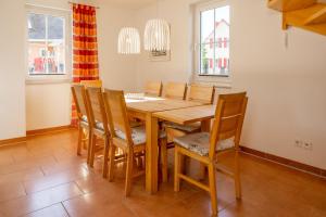 a dining room with a wooden table and chairs at A 7 Ferienhaus Sebastian -eingezäunt- in Gramkow +17 photos