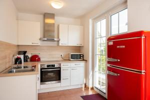a kitchen with a red refrigerator and a sink at B 2 Ferienhaus Nemo in Gramkow
