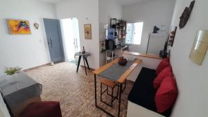 a living room with a red couch and a table at Casa de Praia em Maceió - Camocim - CE in Camocim