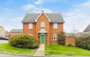a red brick house with a green door at Detached Three Bedroom House in Ashford Secure Area in Kent