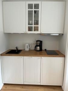 a kitchen with white cabinets and a counter top at Kleine Auszeit Whg 02 in Wyk auf Föhr