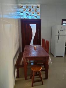 カマサリにあるCasa em condomínio frente Praia Jauá, Bahia Brasilのキッチン(テーブル、椅子、冷蔵庫付)