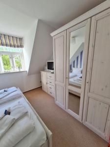 a bedroom with two beds and a large mirror at Schwalbennest in Wyk auf Föhr