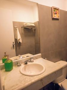 a bathroom with a sink and a mirror at Flat Montese Tower Resende - Refúgio na Serra da Mantiqueira, Próximo à AMAN e Penedo in Resende +5 photos