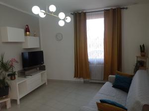 a living room with a couch and a television at Gocce di Rugiada in Medole