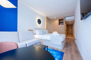 ein Zimmer mit einem Bett, einer Couch und einem Tisch in der Unterkunft Iconic Suites in Madrid