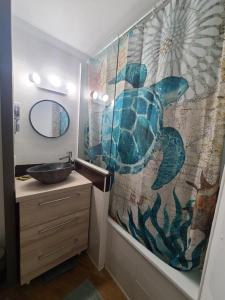 baño con cortina de ducha de tortuga y lavamanos en Rev'Azur Saint Raphaël, en Saint-Raphaël 20 fotos más