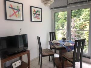 a dining room with a table with chairs and a television at Brühl, FeWo am Heider Bergsee - 3 Sterne DTV in Brühl