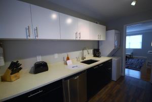a kitchen with white cabinets and a sink at Brookwood Courtyard by BCA Furnished Apartments BCC1B 02 B in Atlanta