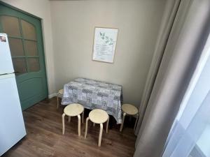 a table and four chairs in a room with a refrigerator at LUX HOME на Дворце Металлургов in Ustʼ-Kamenogorsk +13 photos