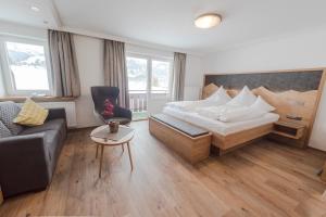 a hotel room with a bed and a couch at Hotel Alpenblick in Fischen