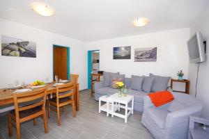 ein Wohnzimmer mit einem blauen Sofa und einem Tisch in der Unterkunft Haus Marienfeld Bungalow "Marcel" in Grömitz