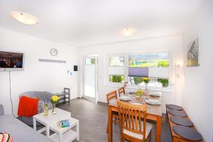 ein Esszimmer und ein Wohnzimmer mit Tisch und Stühlen in der Unterkunft Haus Marienfeld Bungalow "Marcel" in Grömitz