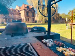 a grill with a kettle and some food on it at Manoir des Étangs in Croissanville
