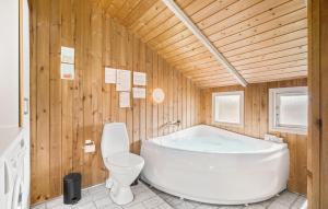 哈夫維格Holiday Home Kr Madsens Vej Hvide Sande Denm的带白色浴缸和马桶的浴室