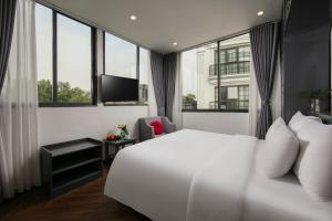 um quarto de hotel com uma cama branca e janelas em La Palm Boutique Hotel em Hanói mais 29 fotografias