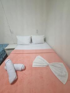 a bed with white socks and a bow on it at Quarto quádruplo in Conde