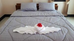 a white bed with a red flower on it at Mirinda Beach Resort in Ban Bo Daeng +6 photos