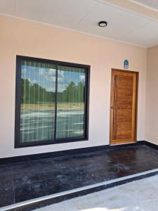 Cette chambre dispose d'une grande fenêtre et d'une porte. dans l'établissement Mirinda Beach Resort, à Ban Bo Daeng