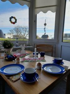 una mesa de madera con placas azules y blancas. en FeWo Seeschloss Nr 5, en Dahme