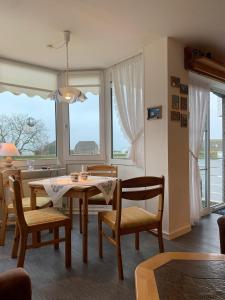 Una sala de estar con mesa y sillas y ventanas. en FeWo Seeschloss Nr 5, en Dahme 6 fotos más