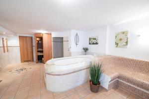 a large bathroom with a tub and a tile floor at Hotel Alpenblick in Fischen +41 photos