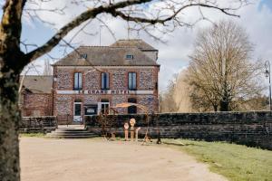 an old brick building with a sign on it at Le Refuge de la Rive in Guichen
