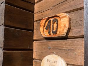 a wooden clock on the side of a wooden wall at Ferienhaus Nr 10, Typ A, Feriendorf Jägerpark, Bayerischer Wald in Prackenbach