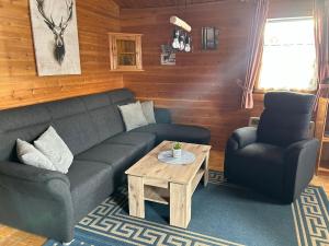 a living room with a couch and a coffee table at Ferienhaus Nr 10, Typ A, Feriendorf Jägerpark, Bayerischer Wald in Prackenbach