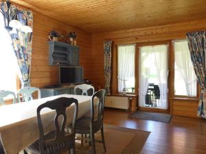 哈瑟尔费尔德Ferienhaus Nr 23, Typ A, Ferienanlage Blauvogel, Hasselfelde, Harz的一间有桌椅和窗户的餐厅