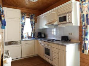 哈瑟尔费尔德Ferienhaus Nr 23, Typ A, Ferienanlage Blauvogel, Hasselfelde, Harz的配有白色橱柜和台面的厨房