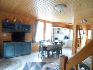 une cuisine et une salle à manger avec une table et des chaises dans l'établissement Ferienhaus Nr 24, Typ A, Ferienanlage Blauvogel, Hasselfelde, Harz, à Hasselfelde