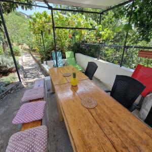a wooden table and chairs on a patio at RELAXED PLACE by the sea in Cesarica