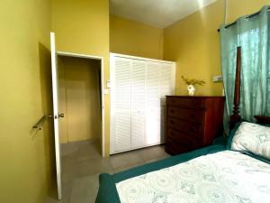 a bedroom with a bed and a dresser and a window at Spacious home near city suite!! in Castries +4 photos