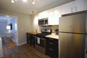 a kitchen with a refrigerator and a table in it at Brookwood Courtyard by BCA Furnished Apartments BCC1B 06 F in Atlanta