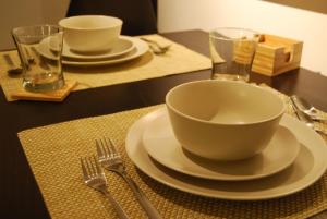 a table with a bowl and plates and forks at Brookwood Courtyard by BCA Furnished Apartments BCC1B 06 F in Atlanta +11 photos
