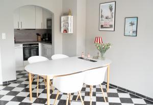 cocina con mesa blanca y sillas blancas en Möwe 44, en Heiligenhafen