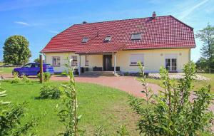 a house with a red roof and a blue car at Ferienwohnung Dabel in Dabel