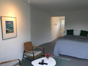 a bedroom with a bed and a table and a chair at Nije Haven Bed & Breakfast in Wrixum