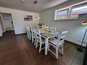 a dining room with a table and white chairs at Ferienhaus in der Schleife 2 in Rendsburg in Rendsburg