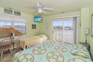 una camera da letto con due letti, una scrivania e una finestra di Bay Daze - Waterfront townhome w private boat dock! a Chincoteague