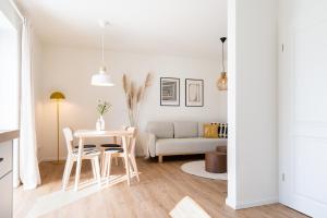a white living room with a table and chairs at Küstenbutze im modernen Scandi-Style mit Garten und Terrasse in Mildstedt