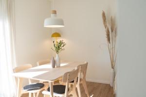 a dining room with a white table and chairs at Küstenbutze im modernen Scandi-Style mit Garten und Terrasse in Mildstedt