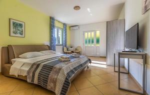 a bedroom with a bed and a flat screen tv at Stunning Apartment In Medulin With Wifi in Medulin