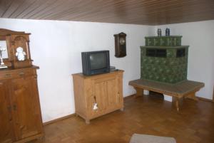 ein Wohnzimmer mit einem TV und einem Holzschrank in der Unterkunft Ferienhaus, Bauernhof mit Angel- und Badesee, Roßhaupten, Allgäu in Roßhaupten