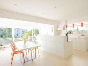 a kitchen with white cabinets and a table and chairs at CasaSol Deluxe villa sulla Spiaggia con Piscina e Jacuzzi By Sicily Home Solutions in Alcamo