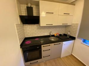 a small kitchen with a sink and a stove at Orange&Lemon Villas Çamyuva in Kemer