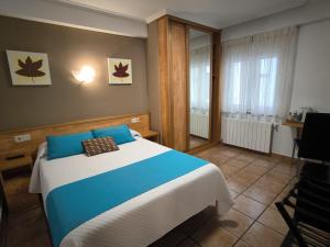 a bedroom with a blue and white bed and a window at Hostería VISTAPARK in El Astillero