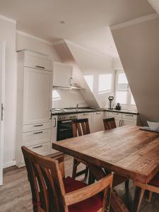 a kitchen with a wooden table and chairs at Inselperle Kämmererhof in Fehmarn